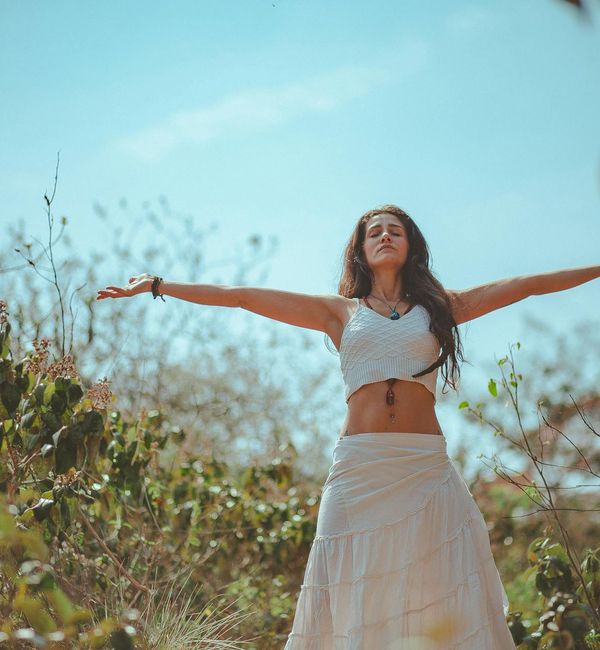 Person meditating in a serene natural environment with sunlight.